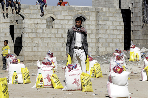 TOPSHOT- A Yemeni man receives food aid from a Yemeni philanthropist who provides aid parcels to families affected by the ongoing conflict between loyalist forces and Huthi rebels