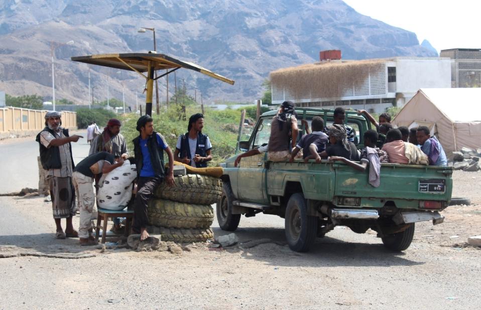 African migrants who were reportedly smuggled by sea into Yemen sit on the back of a vehicle after they were detained by Yemeni fighters loyal to Yemen's President Abedrabbo Mansour Hadi on the outskirts of the city of Aden