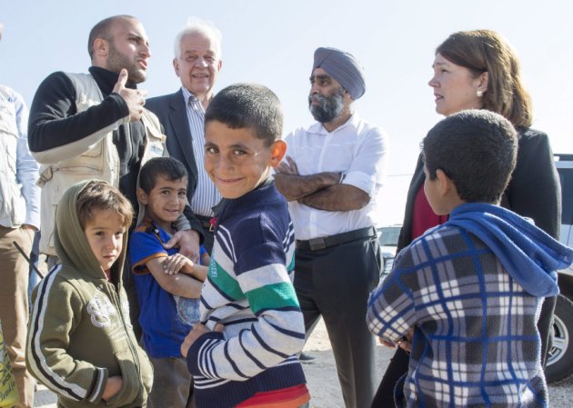 Young Syrian refugees gather around Minister of Immigration Refugees and Citizenship John McCallum second from left Defence Minister Harjit Sajjan and Health Minister Jane Philpott right as they tour the Zaatari Refugee Camp near the city of Mafraq