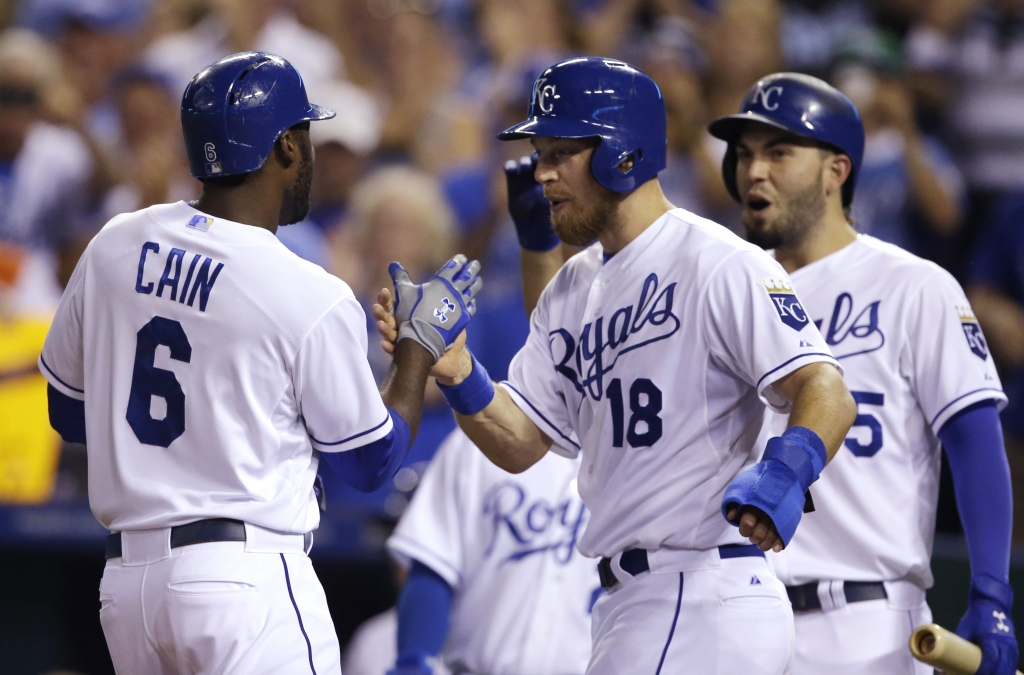 Kansas City Royals center fielder Lorenzo Cain is congratulated by teammates Ben Zobrist and Eric Hosmer right after hitting a three-run home run during the second inning of a baseball game against the Detroit Tigers at Kauffman Stadium in Kans