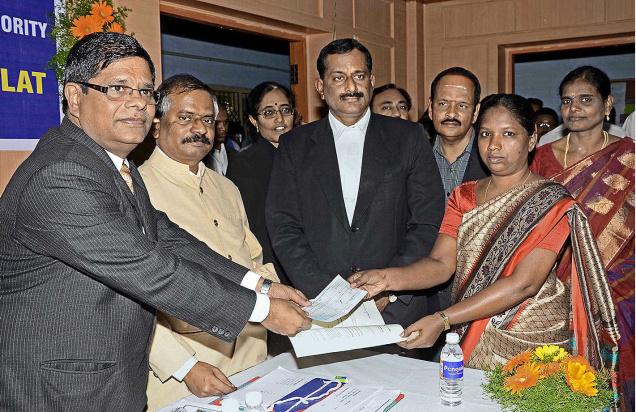 FINAL INTERVENTION:Principal District Judge G.P. Elango hands over settlement documents to a litigant during the Lok Adalat in Erode on Saturday