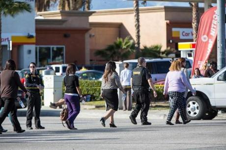 Evacuees are taken to a safe location away from the site of a mass shooting in San Bernardino Calif. Dec. 2 2015. Police mounted an intense manhunt for gunmen who had fired dozens of shots Wednesday inside a conference hall where county employees had