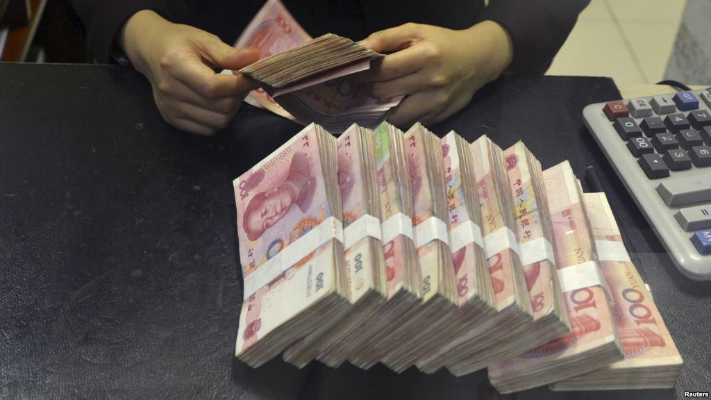 FILE- A clerk counts 100 Chinese yuan banknotes at a branch of China Merchants Bank in Hefei Anhui province