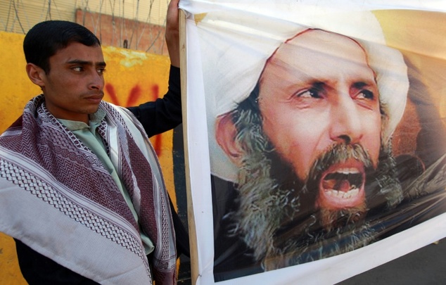 A Shiite supporter holds a portrait of Nimr al Nimr during a 2014 protest in Saana against his death penalty