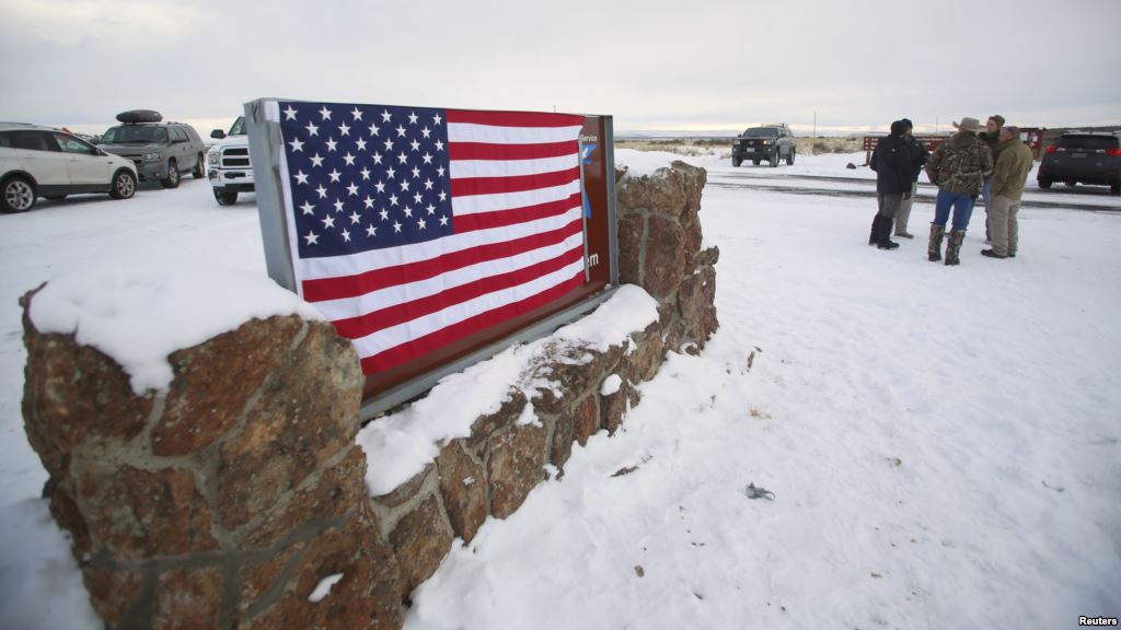 A U.S. flag covers a sign at the entrance of the Malheur National Wildlife Refuge near Burns Oregon Jan. 3 2016