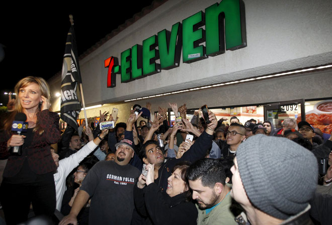 A crowd gathers in front of the 7 Eleven store where a winning Powerball ticket was sold in Chino Hills California. — Reuters