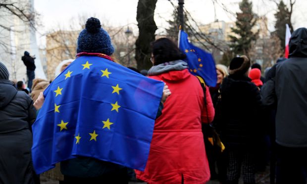 A demonstrator outside the Polish Parliament wears the European Union flag