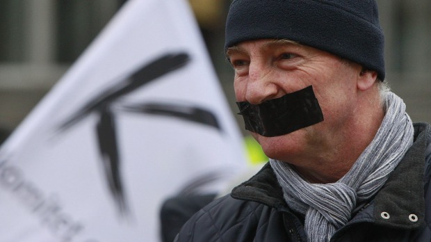 A demonstrator seals his mouth during a protest over media freedom at the Polish TVP News headquarters in Warsaw