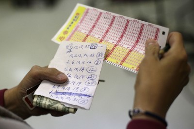 A player checks her Powerball lottery numbers in a drawing. This week the Powerball lottery prize is expected to hit $400 million