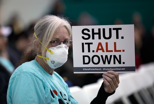 A woman holds a sign while attending a public hearing on January 16 regarding the massive natural-gas leak near Porter Ranch California