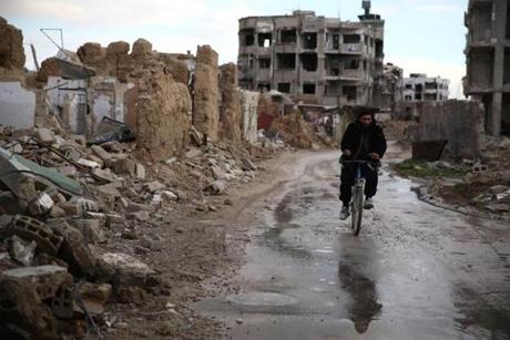 A man rode a bicycle through Damascus on Sunday. Some areas around the capital recently have been blockaded