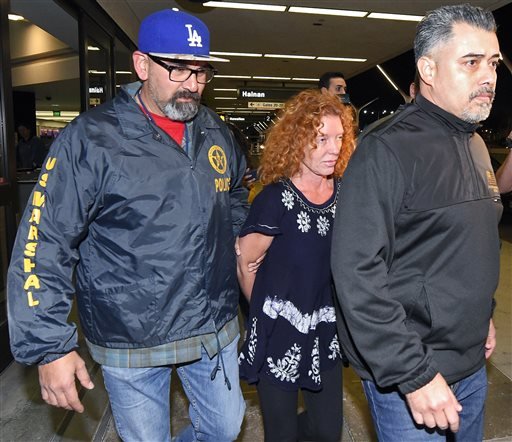 Tonya Couch center is taken by authorities to a waiting car after arriving at Los Angeles International Airport Thursday Dec. 31 2015 in Los Angeles. Authorities said she and her son Texas teenager Ethan Couch who was sentenced to probation after