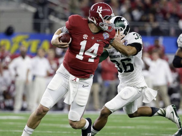 Alabama quarterback Jake Coker is pressured out of the pocket by Michigan State cornerback Arjen Colquhoun during the first half of the Cotton Bowl NCAA college football semifinal playoff game Thursday Dec. 31 2015 in Arlington Texas. (AP