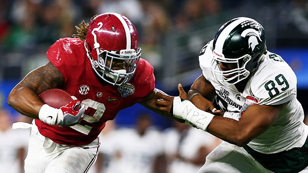 Running back Derrick Henry of the Alabama Crimson Tide stiff arms defensive end Shilique Calhoun and then runs for a touchdown in the fourth quarter against the Michigan State Spartans during the Goodyear Cotton Bowl at AT&T Stadium