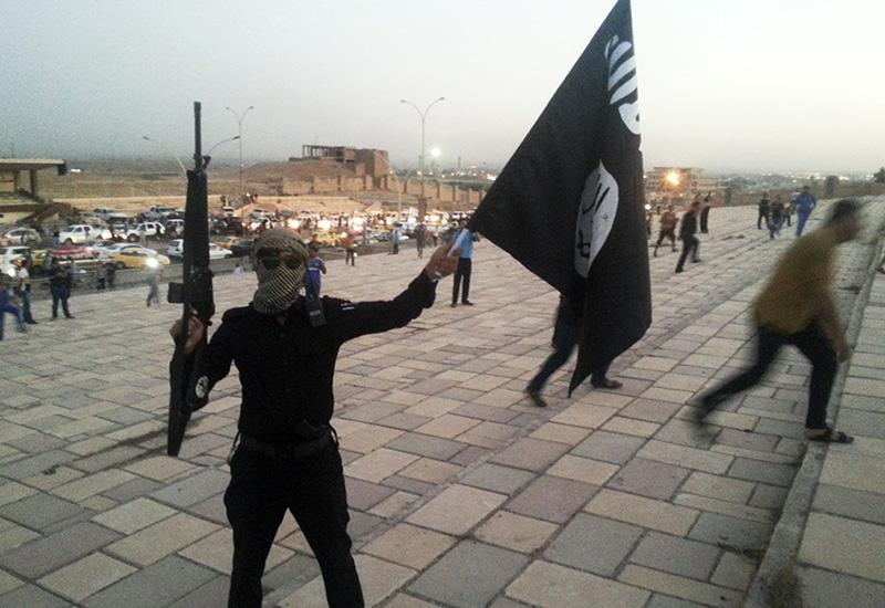 An Isis fighter waves the group's black standard