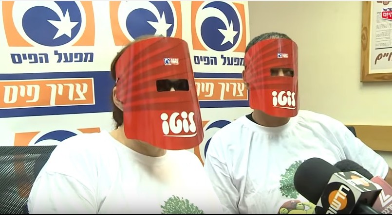 An Israeli couple keep their identities hidden as they collect their lottery winnings in May 2013