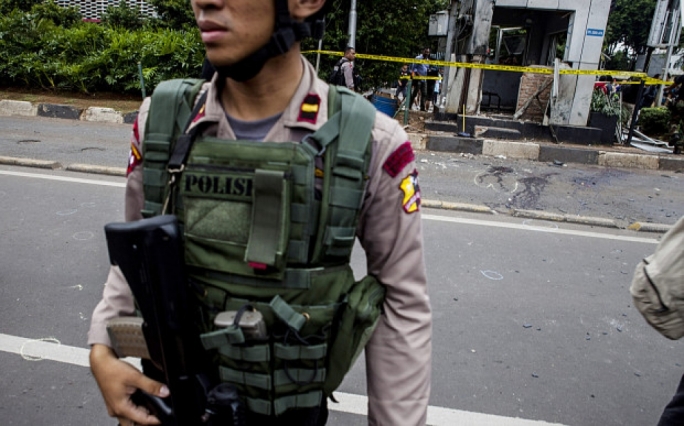 Armed police stand guard at the scene of the bombing