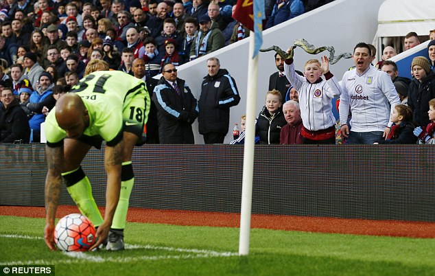 Aston Villa fans gesture towards Manchester City's Fabian Delph as he prepares to take a corner kick