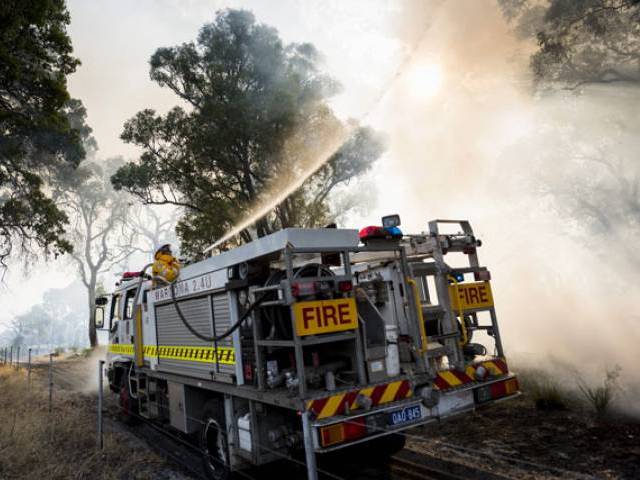 7 2016 and released by the Department of Fire and Emergency Services shows firemen tackling a bushfire burning near Waroona some 110 kilometres south of Perth