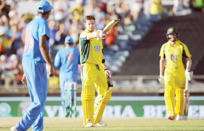 Australia’s captain Steve Smith raises his bat after reaching his century during their ODI against India in Perth Tuesday. — AFP