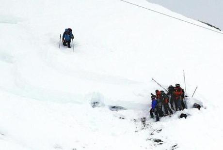 DEADLY SNOWSLIDE — Members of a rescue team searched the snow for a group of missing people that included a party of schoolchildren who were swept away by an avalanche in Les Deux Alpes France on Thursday. At least three people were killed including