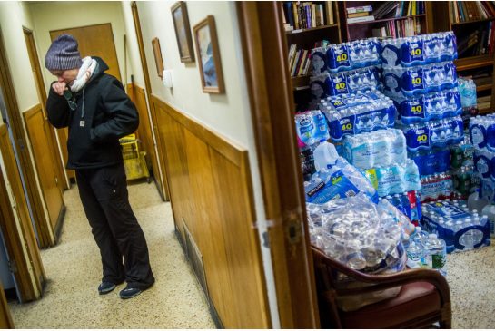 Terra Castro wipes away tears Saturday after she and about 20 Detroit-based volunteers dropped off more than 500 cases of bottled water at Mission of Hope in Flint