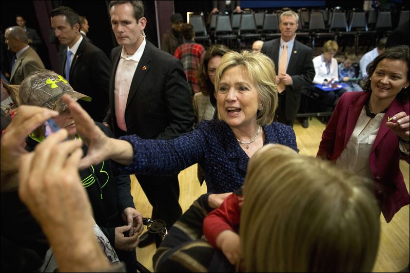 Democratic presidential candidate Hillary Clinton reaches for a smartphone for a selfie with a supporter after a campaign rally today in Waterloo Iowa