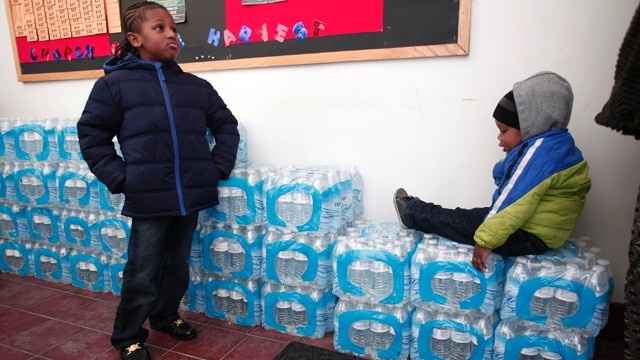 Staff Sergeant William Phillips of Birch Run Michigan helps unload pallets of bottled water at a Flint Fire Station Jan. 13 2016 in Flint Michigan