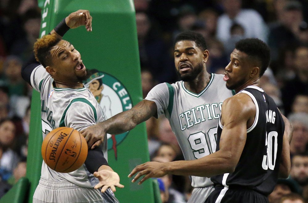 Boston’s Jared Sullinger left and Amir Johnson and Brooklyn’s Thaddeus Young battle for the ball Saturday in Boston