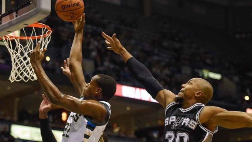 Monday Jan. 4 Milwaukee Bucks guard Khris Middleton takes a shot against San Antonio Spurs forward David West in the first quarter at BMO Harris Bradley Center in Milwaukee Wis