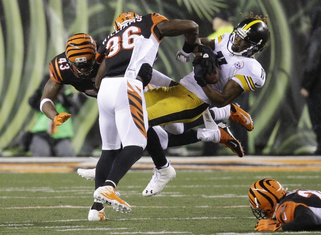 Pittsburgh Steelers&#039 Markus Wheaton is tackled by Cincinnati Bengals&#039 Shawn Williams and George Iloka during the first half of an NFL wild-card playoff football game Saturday Jan. 9 2016 in Cincinnati