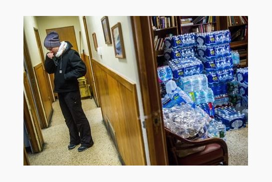 St. Clair Shores resident Terra Castro wipes away tears as she takes a moment to reflect on the state of emergency in Flint while dropping off more than 500 cases of bottled water with about 20 Detroit-based volunteers on Saturday Jan. 16 2016 at Missi