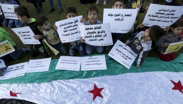 Children hold signs calling for the lifting of sieges in Syria outside U.N. headquarters in Beirut Lebanon