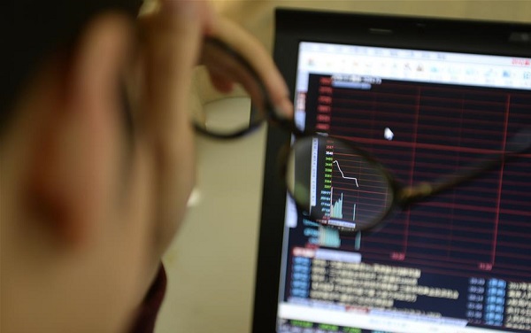 An investor looks through stock information at a trading hall in a securities firm in Hangzhou capital of east China's Zhejiang Province Jan. 7 2016