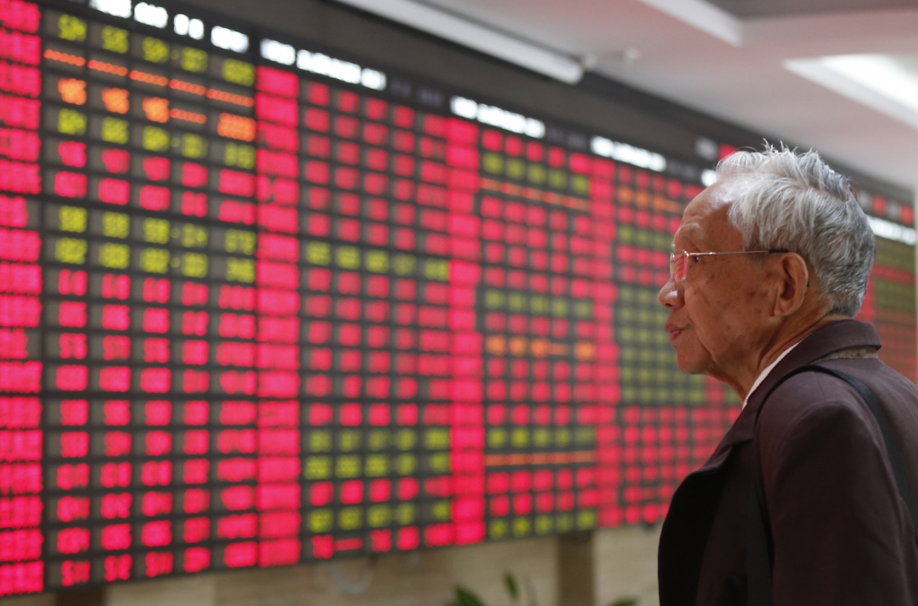 An investor looks at the stock price monitor at a private securities company Monday Nov. 25 2013 in Shanghai China. Asian markets were mixed on Tuesday following a muted lead from Wall Street. AP