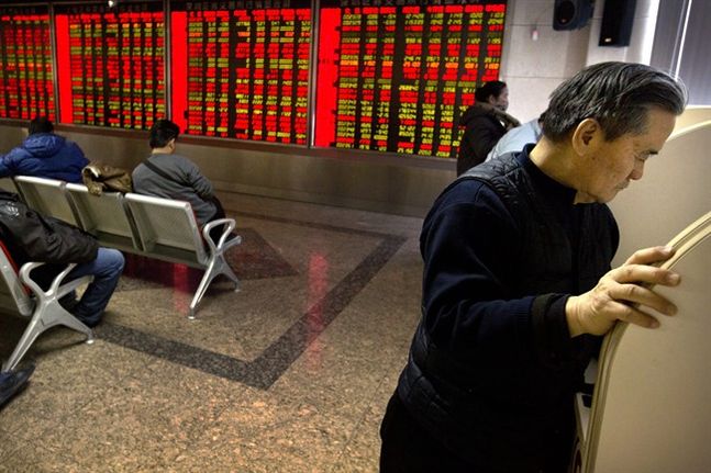 A Chinese investor uses a computer terminal to check stock prices in a brokerage house in Beijing Friday Jan. 8 2016. Chinese stocks were volatile Friday and other Asian markets rebounded after a plunge in Chinese prices rattled global markets. (AP Pho