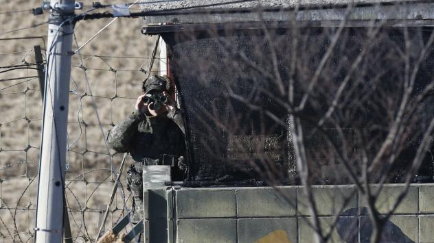 A South Korean soldier looks through a pair of binoculars near the village of Panmunjom which sits at the border between the two Koreas