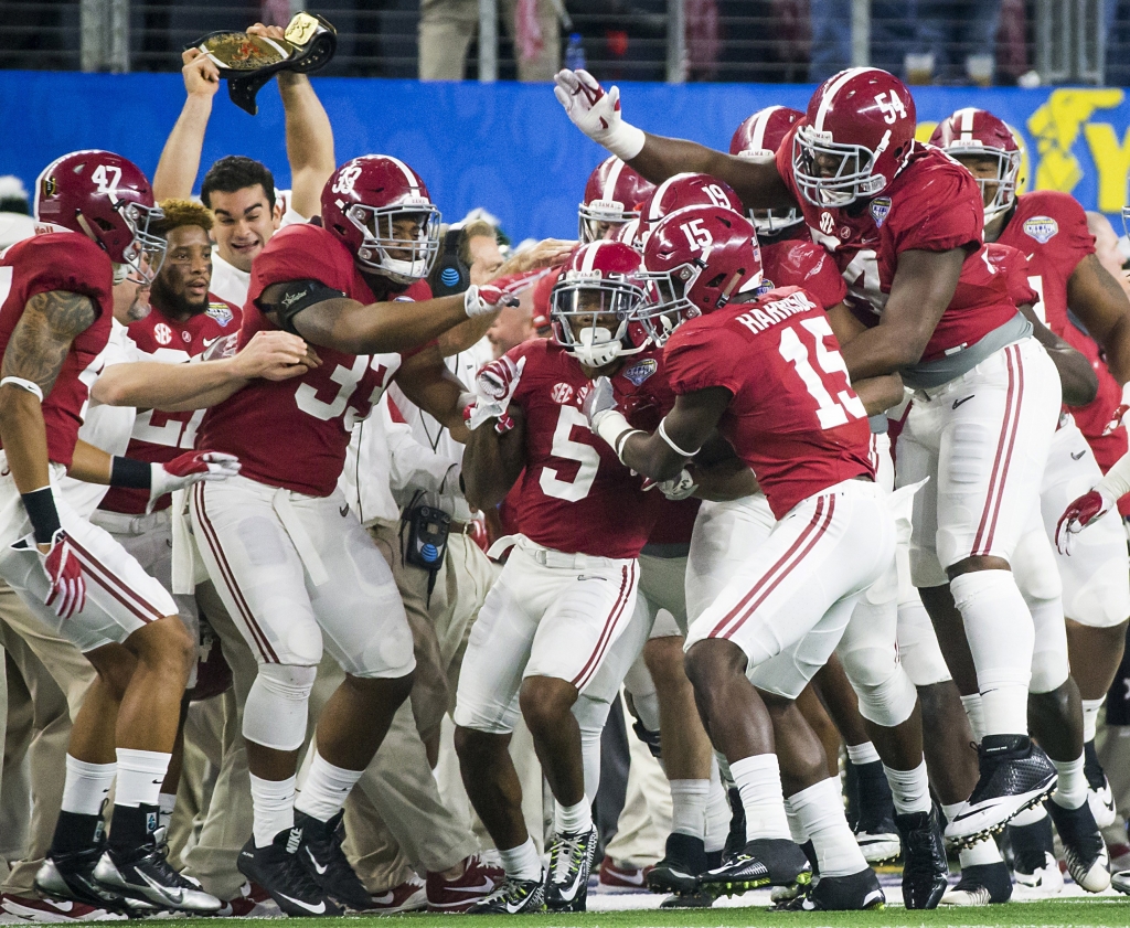 Alabama defensive back Cyrus Jones is mobbed by teammates after intercepting a pass in the end zone during the first half