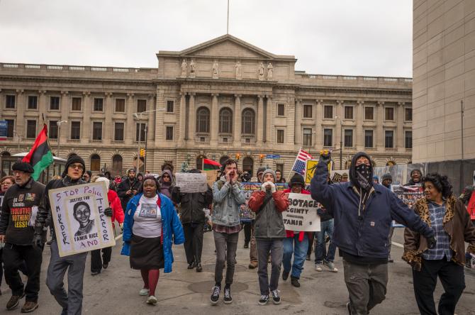 502831192-protestors-march-on-e-6th-st-in-front-of-city-hall-on