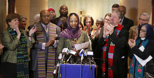 Wheaton College associate professor Larycia Hawkins Phd. center is greeted with applause from supporters as she begins her remarks during a news conference Wednesday Dec. 16 2015 in Chicago. Hawkins a Christian teaching political science at the priv