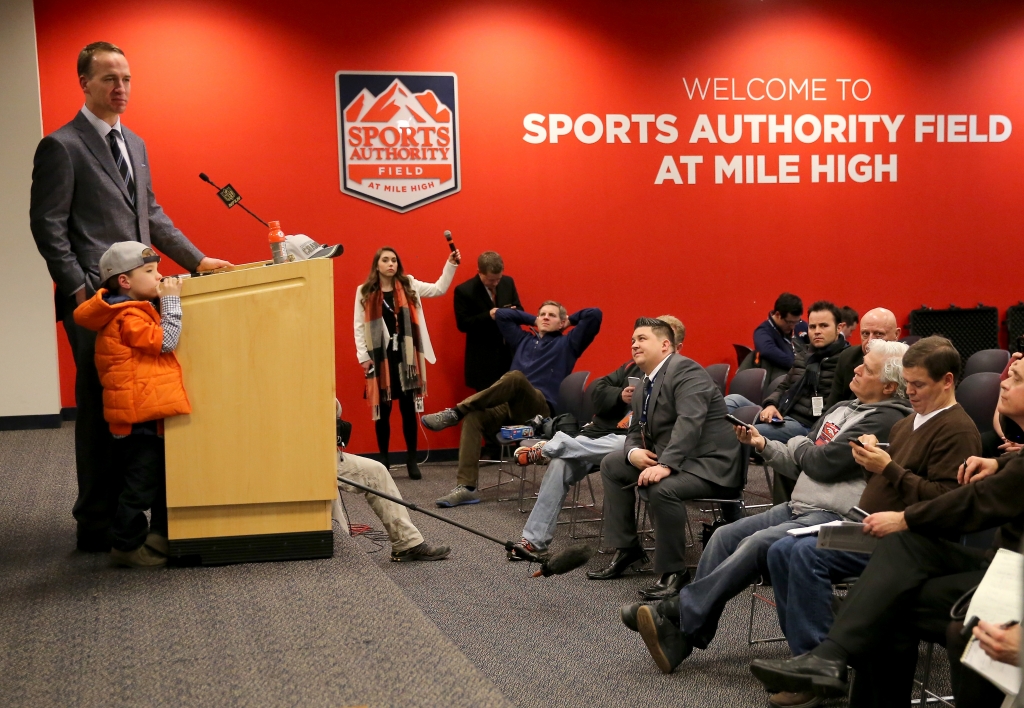 Peyton Manning of the Denver Broncos speaks in a postgame press conference with his son Marshall Manning after defeating the New England Patriots in the AFC Championship game at Sports Authority Field at Mile High on Jan. 24 2016. The Broncos defeated