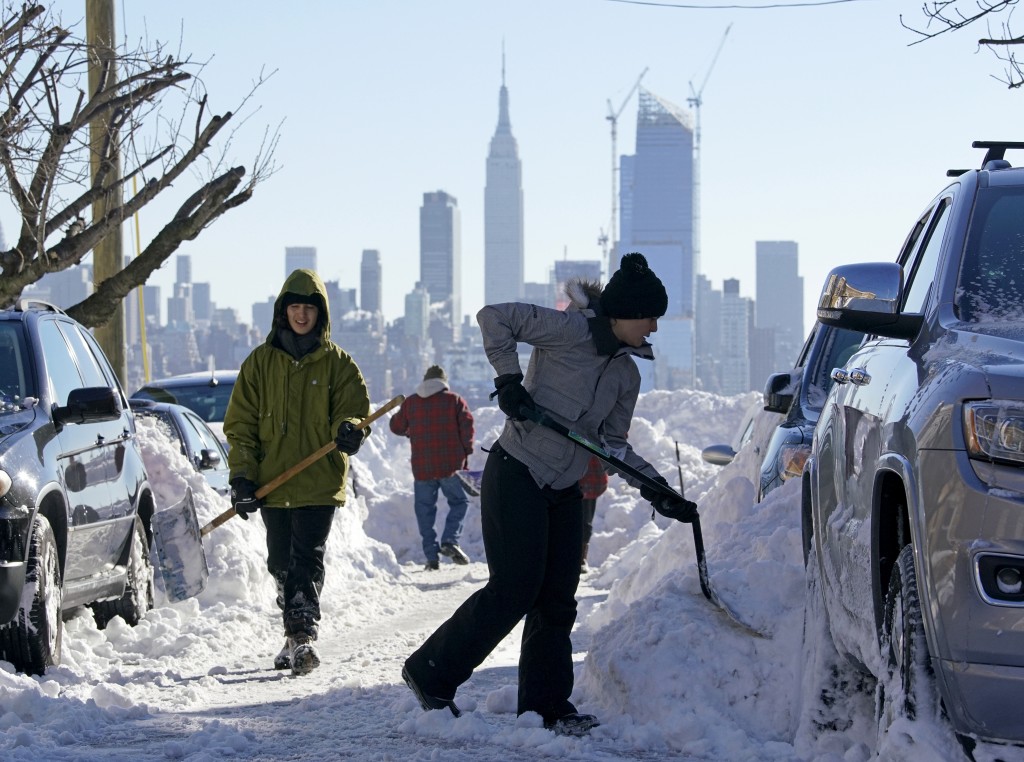 Residents clear their street of snow in Union City New Jersey across the Hudson River from Midtown Manhattan after the second-biggest winter storm in New York history Jan. 24 2016