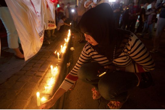 An Indonesian woman lights candles near the site of Thursday's terrorist attack where a Canadian was killed