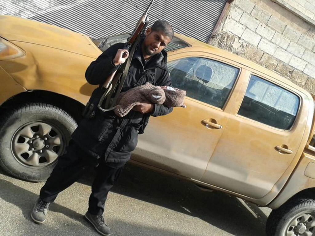 Siddhartha Dhar holds an assault rifle and his infant son soon after his arrival in Syria