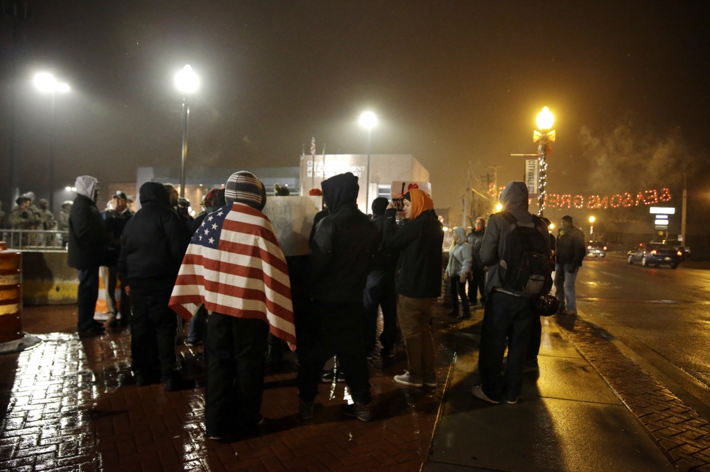 A group of protesters gather in front of the Ferguson Police Department Wednesday Nov. 26 2014 in Ferguson Mo. A grand jury's decision not to indict a police officer in the shooting death of an unarmed 18-year-old has stoked passions nationwide