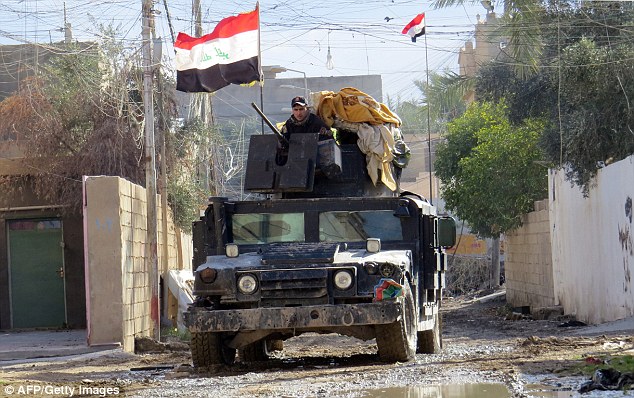 Iraqi pro-government forces drive a military vehicle during battles with ISIS in Ramadi