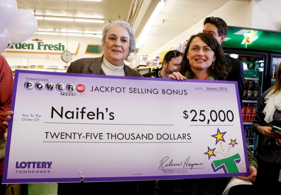 Rebecca Hargrove left president & CEO of the Tennessee Lottery presents a check to Dana Naifeh right owner of Naifeh's Grocery in Munford Tenn. Thursday Jan. 14 2016. One of the winning Powerball tickets in Wednesday's record jackpot drawing