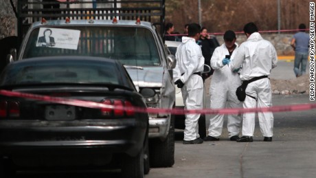 Forensic investigators gather outside residence of slain mayor