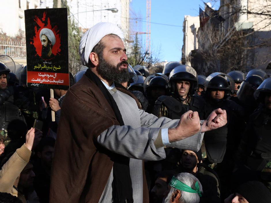 A Muslim cleric addresses a crowd during a demonstration to protest the execution of Saudi Shiite Sheikh Nimr al-Nimr seen in poster in front of the Saudi embassy in Tehran Iran Sunday