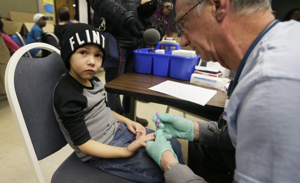 Brian Jones a nurse draws a blood sample from Grayling Stefek 5 at the Eisenhower Elementary School on Tuesday in Flint Mich. The students were being tested for lead